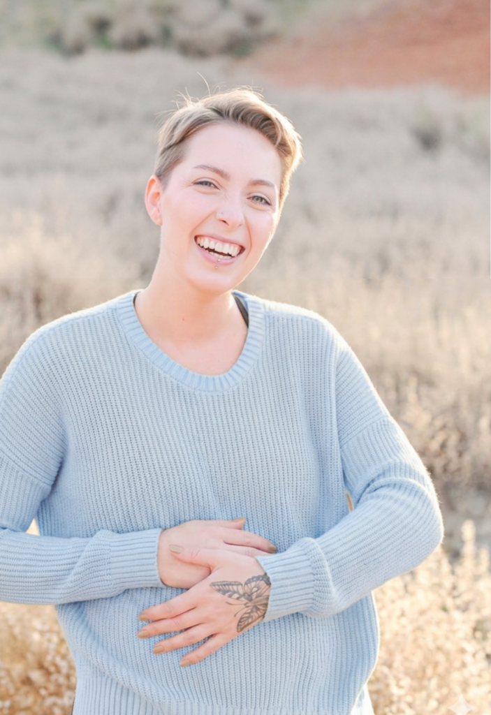 short-haired woman in a blue top in a sunlit field